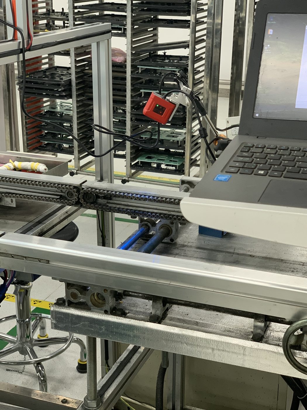 Compact red code reader mounted at a PCB magazine rack